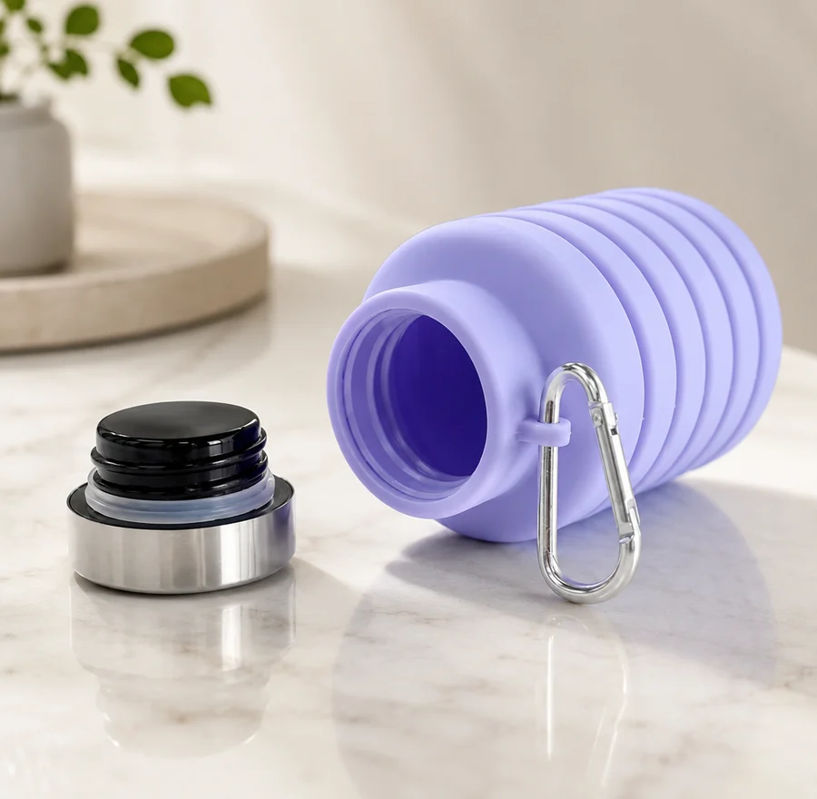 A Lavender silicone bottle lying on its side with the stainless steel cap unscrewed beside it