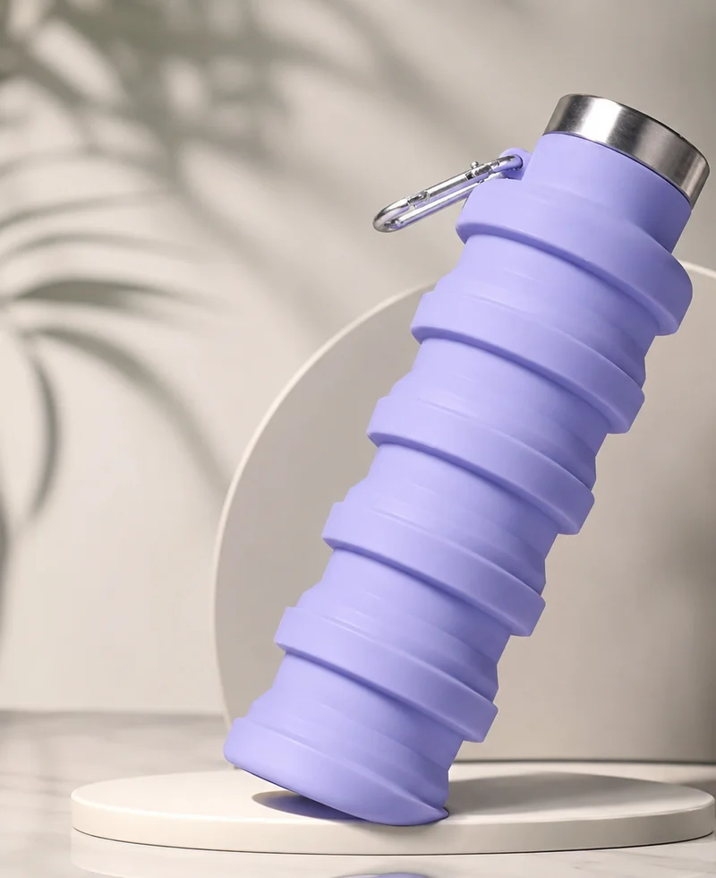 A Lavender silicone bottle standing on a pale display pedestal in soft daylight