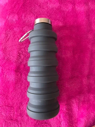 Collapsible silicone water bottle squeezed down flat in a buyer's hand — photo from a verified buyer
