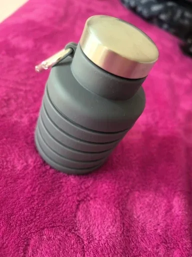 Sage collapsible bottle folded down on a surface